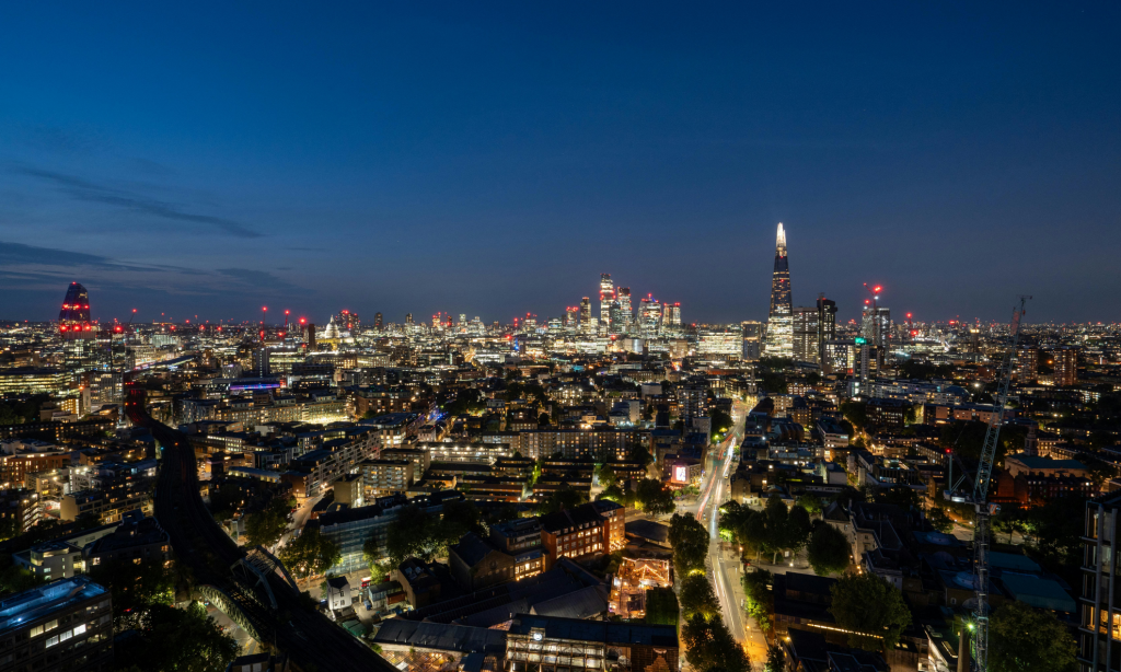 A night-time panorama of London showing illuminated buildings, including The Shard and the City’s financial district.